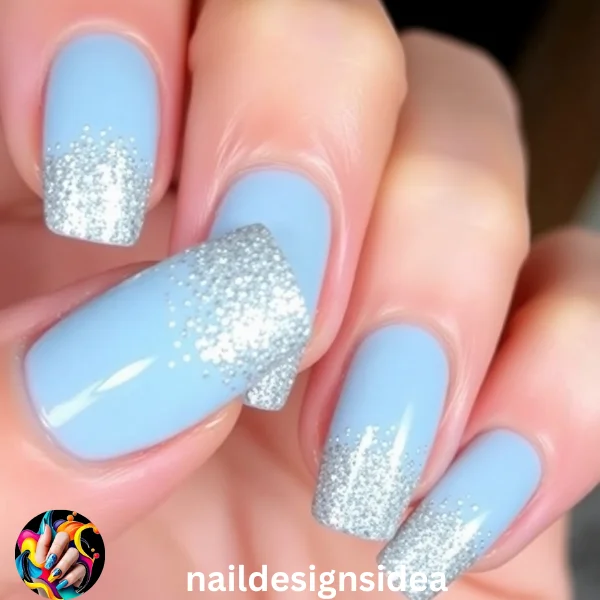 Apply baby blue polish as the base color, then gradually add silver glitter towards the nail tips or cuticle. 