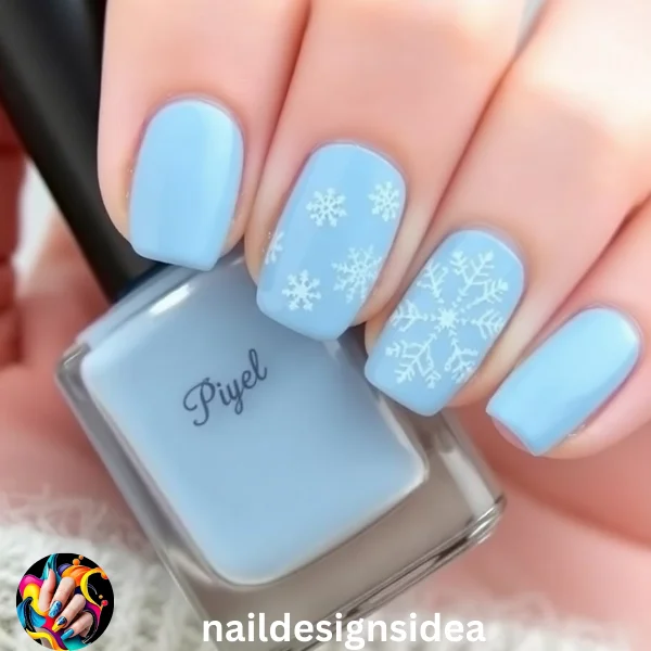 Start with a baby blue base and use a fine nail art brush or stencils to paint delicate white snowflakes on one or two nails. 