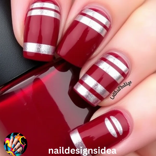 Dark red nails with silver stripes create a striking look that’s both festive and chic. 